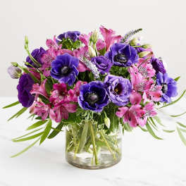 Purple and pink mixed bouquet in a clear glass vase
