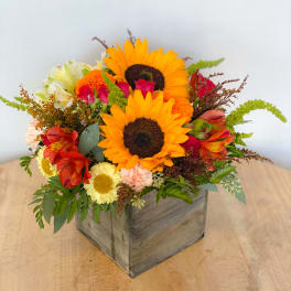 Mixed bouquet with sunflowers in a wooden box