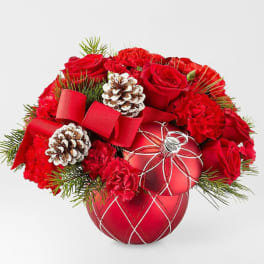 Red roses and carnations arranged with pinecones in a red ornament vase