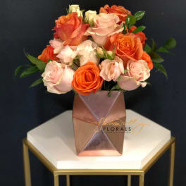 Bouquet of pink and orange roses in a geometric vase