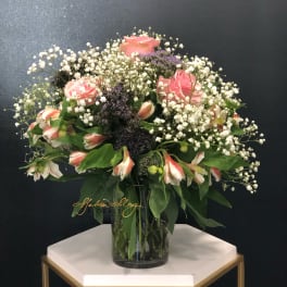 Pink roses and white alstroemeria in a glass vase