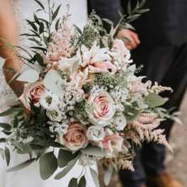 Wedding bouquet of blush roses and white flowers with airy greenery