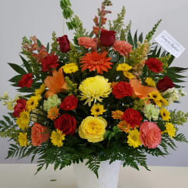 Colorful mixed flower arrangement in a white vase
