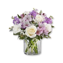 Bouquet of white and purple flowers in a clear glass vase