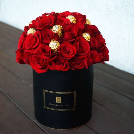 Red roses with gold chocolates in a black box