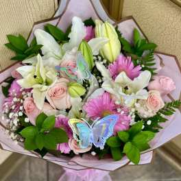 Bouquet of pink roses, white lilies, and pink daisies with butterfly picks