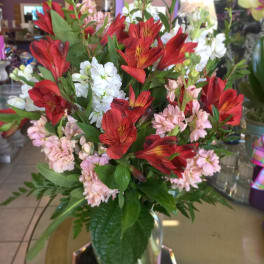 Bouquet of red and pink flowers in a clear glass vase