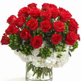Red roses and white carnations in a clear glass vase