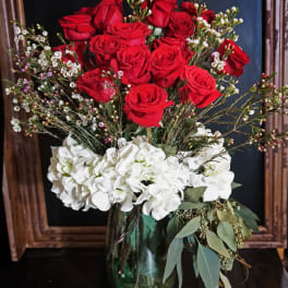Red roses and white hydrangeas in a glass vase