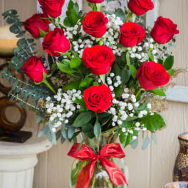 Bouquet of red roses in a glass vase with a red ribbon