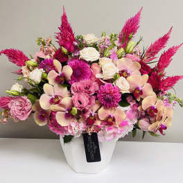 Pink and cream floral arrangement in a white vase