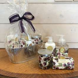 Cherry-themed bath and body gift set in a metal tub wrapped in cellophane with a dark ribbon bow
