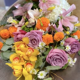 Bouquet of pink lilies, purple roses, and orange marigolds