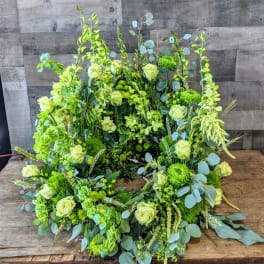 Large circular wreath of pale green roses and green blooms in a lush garden style.