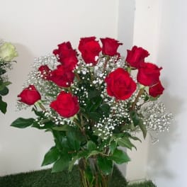 Bouquet of red roses with white baby's breath in a clear vase