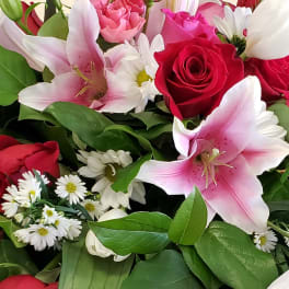 Bouquet of pink lilies, red roses, and white daisies