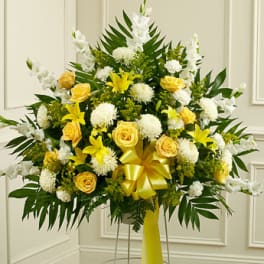 Yellow and white floral standing arrangement with a ribbon bow