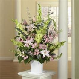 Tall pastel floral arrangement in a white vase
