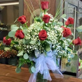 Bouquet of red roses with baby's breath in a glass vase