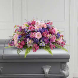 Pink and purple flower arrangement on a gray casket