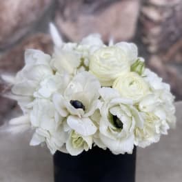 White floral bouquet in a black cylindrical vase