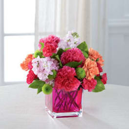 Pink and peach carnations in a pink glass vase