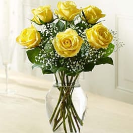 Yellow roses arranged in a clear glass vase