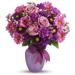 Pink and purple bouquet in a lavender vase with a ribbon