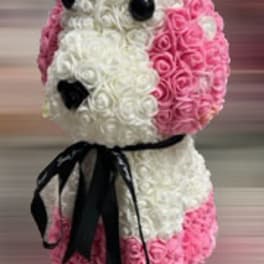 Pink and white rose arrangement shaped like a dog with a black ribbon
