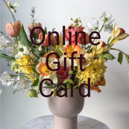 Mixed bouquet in a pale vase with tulips and white blossoms