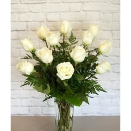 White roses arranged in a clear glass vase