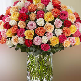 Large bouquet of multicolored roses in a clear glass vase