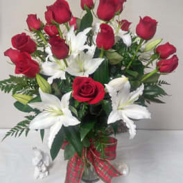 Bouquet of red roses and white lilies in a glass vase