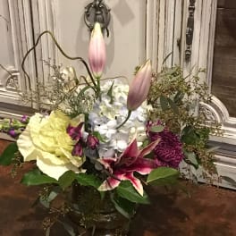 Mixed floral arrangement with lilies, hydrangea, and chrysanthemums in a vase