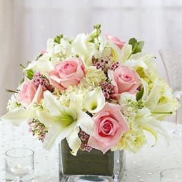 Pink roses and white lilies in a square glass vase