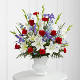 Red roses, white lilies, and purple flowers in a white vase