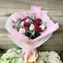 Bouquet of red and pink roses wrapped in pink paper