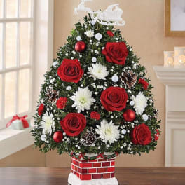 Christmas tree-shaped floral arrangement with red roses and white blooms