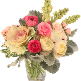 Bouquet of pink and cream flowers in a clear glass vase