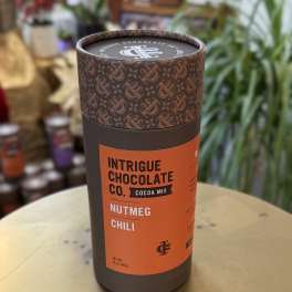 A cylindrical tin of cocoa mix labeled Nutmeg Chili.