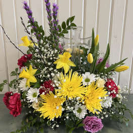 Colorful floral arrangement with a clear glass cross centerpiece