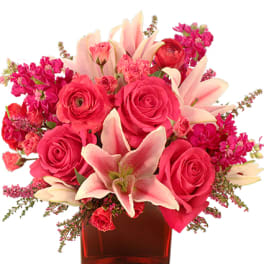 Pink roses and lilies in a red glass vase