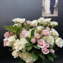 Pink and white roses arranged in a clear glass vase