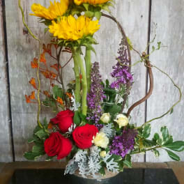 Sunflower and rose arrangement in a round metal container