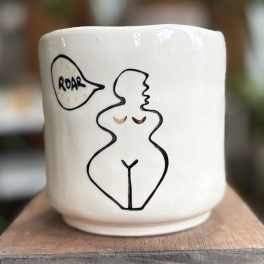 White ceramic mug with a line drawing of a nude figure and a speech bubble
