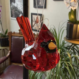 Red glass bird ornament hanging indoors
