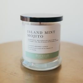 Glass candle jar with a black lid and Island Mint Mojito label