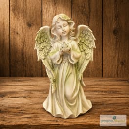 Angel figurine holding a small bird on a wooden surface