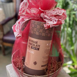 Gift basket with a cocoa mix tin wrapped in red mesh ribbon