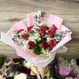 Bouquet of red roses with white baby's breath in pink wrapping